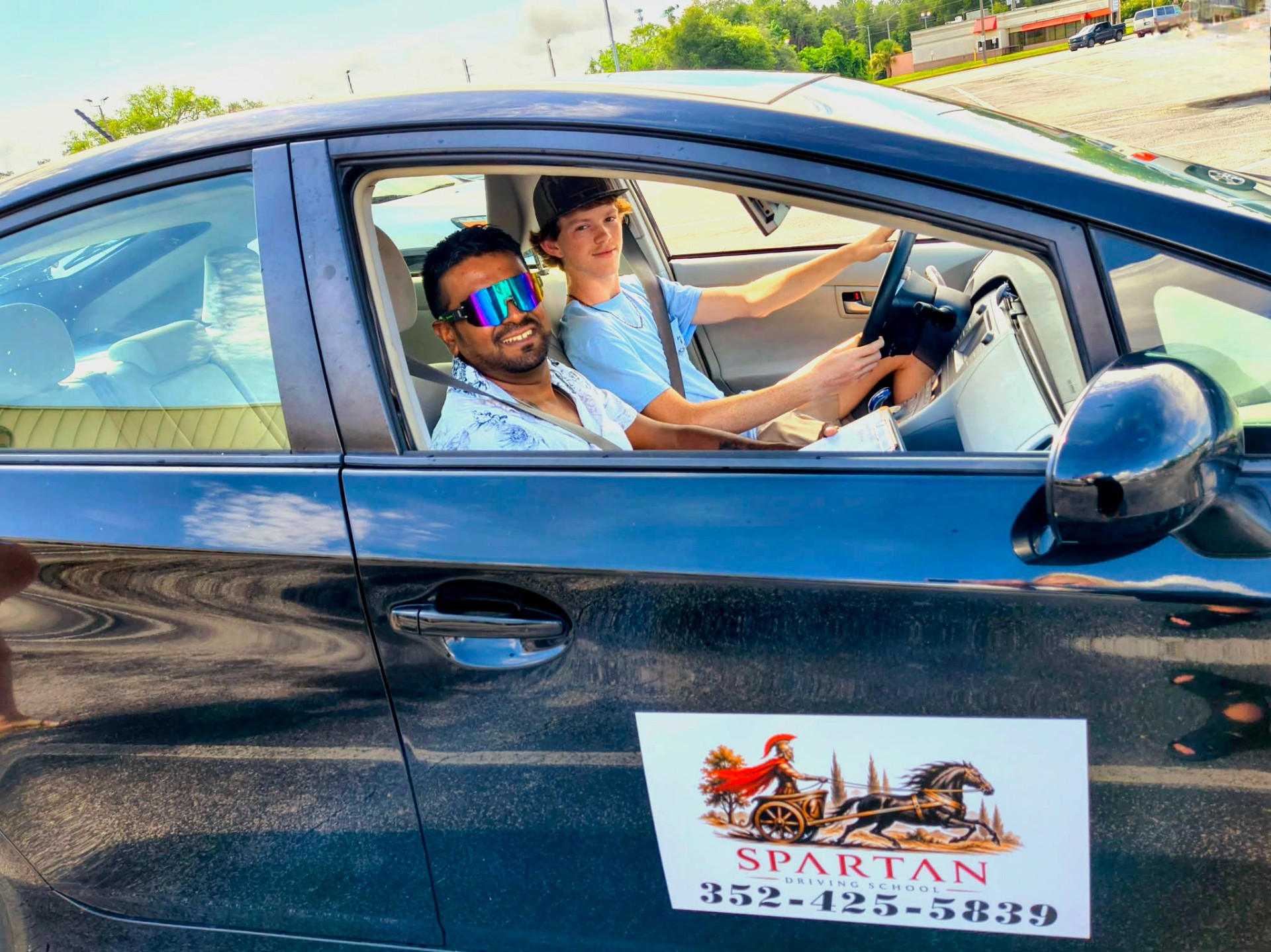 Spartan instructor and smiling student during an in-car driving lesson
