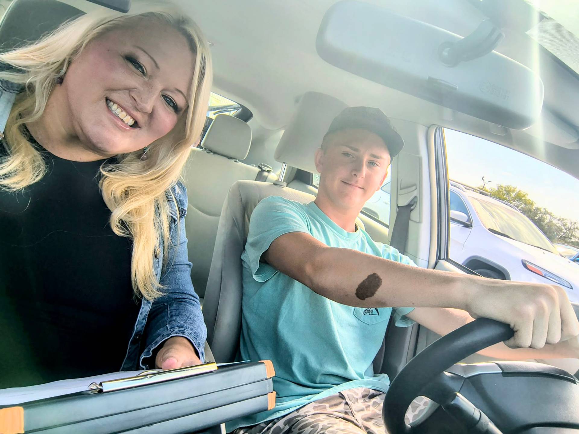 Spartan instructor coaching a smiling student driver in the car